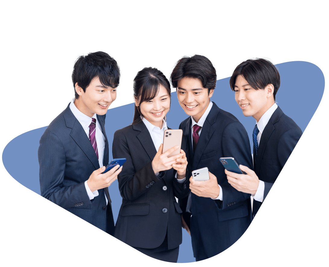 4人の男女が並んで、笑顔で1人が持つスマートフォンを覗いている様子